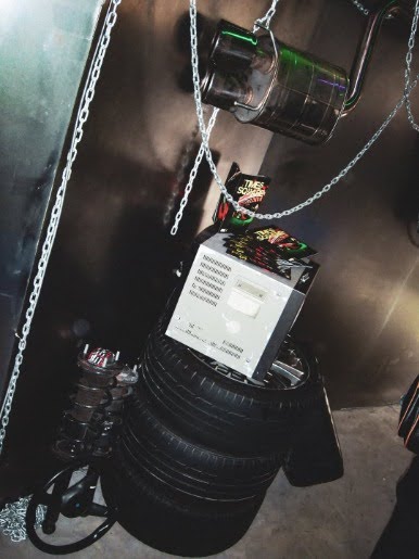 A second screen on a tire stack. Four displays let a year of photography run as sequences rather than as prints competing for the same wall